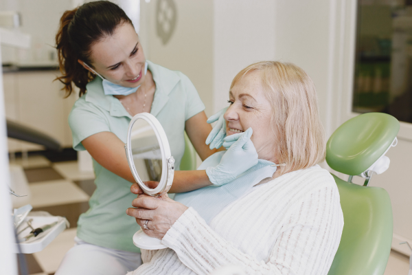 Dentist showing a dental implant model to a patient at a Terrigal implant centre on the Central Coast